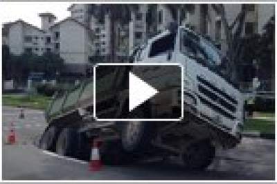 Tipper truck stuck in sink hole after ground gives way